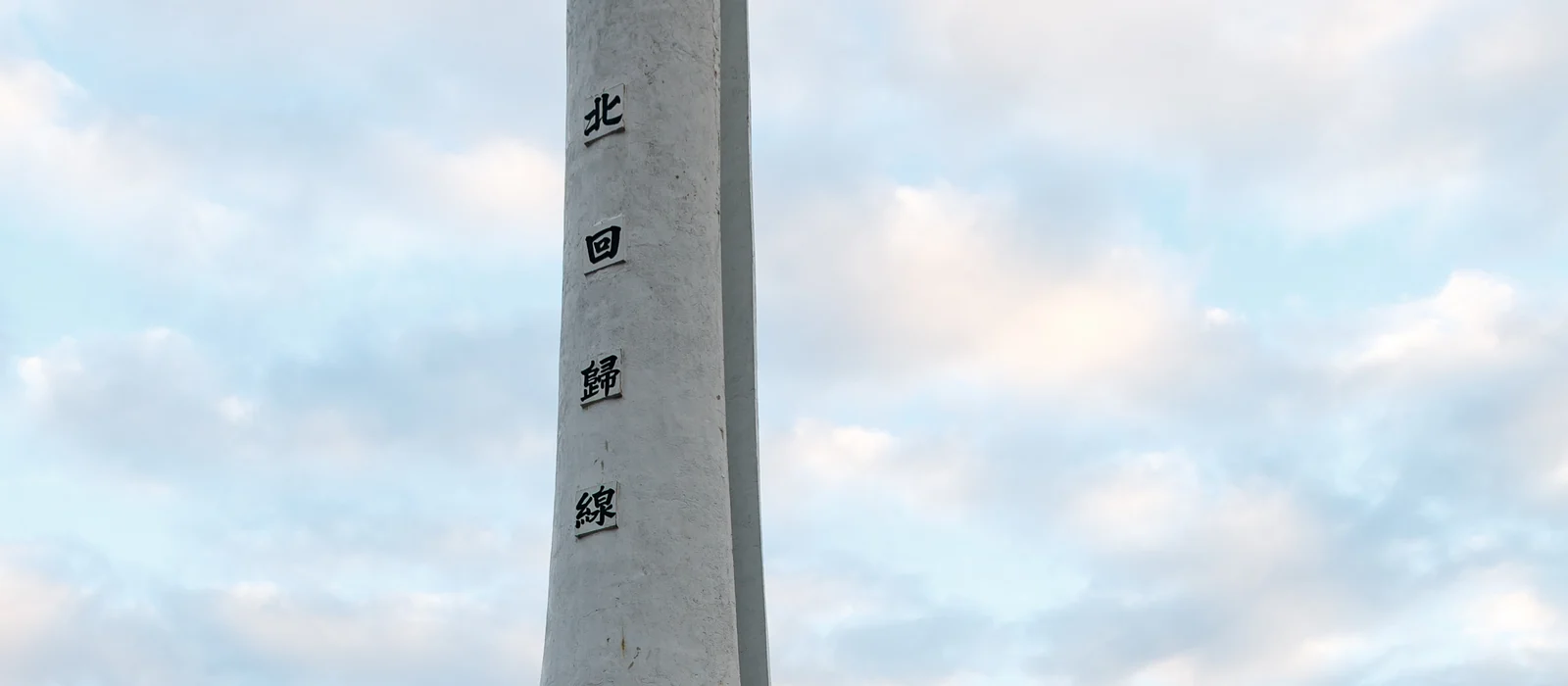 北回歸線標誌碑與海岸植物的橫幅景觀